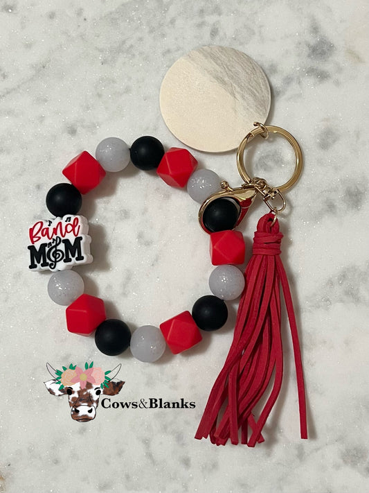 Band Mom Stretch Silicone Wristlet with Red Tassel and Wooden Disk.
