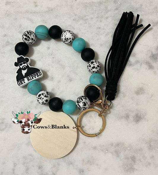 Rip Ranch Stretch Silicone Wristlet With Black, Teal, and White Cow Print Silicone Beads.